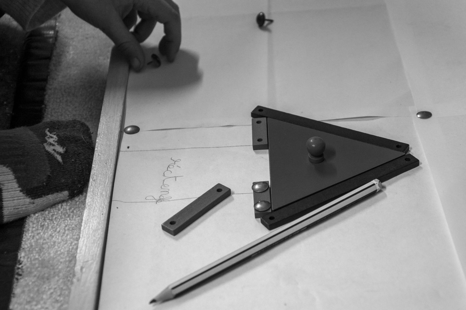 Une équerre, une règle et un crayon posés sur une feuille : une leçon de géométrie