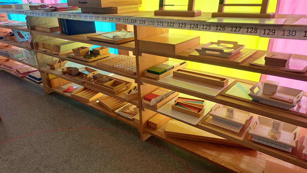 Les étagères d’une classe, garnies de matériel Montessori en bois