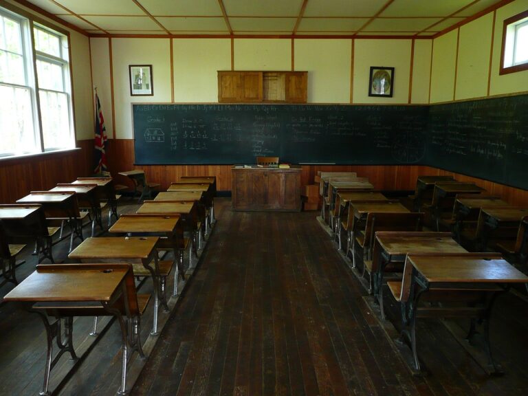 Une salle de classe d'autrefois, avec ses pupitres en bois alignés face au tableau noir